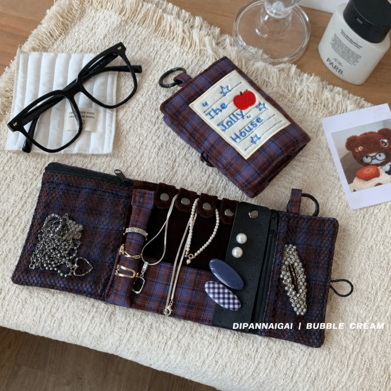 Fold-out jewelry case beside a handbag