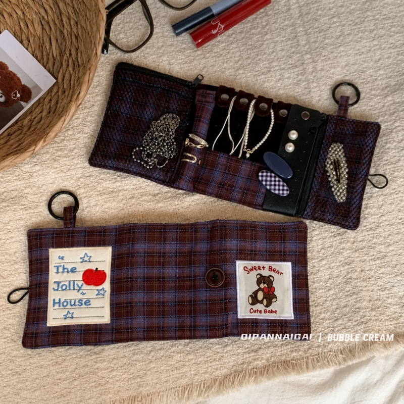 Open organizer with necklace tabs, ring holder, and zip pockets